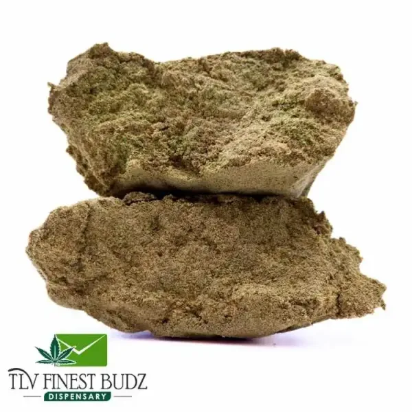 Close-up of two textured, light brown cannabis nuggets stacked on top of each other, with a dispensary logo at the bottom.
