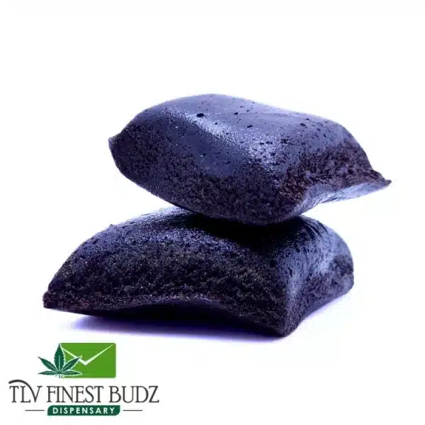 Two rectangular pieces of dark, glossy cannabis concentrate stacked on a white background, with a dispensary logo below.